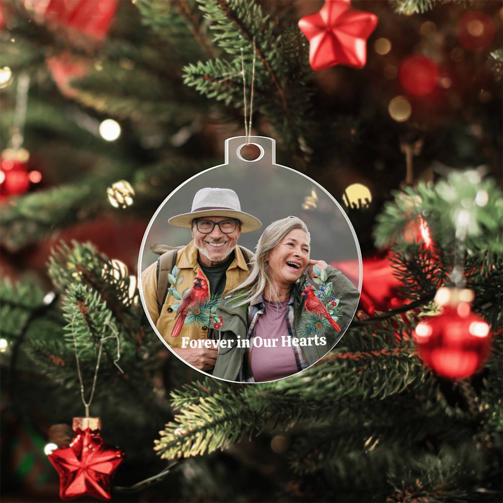 Personalized Christmas ornament with a couple's photo and 'Forever in Our Hearts' text, hanging on a decorated tree.