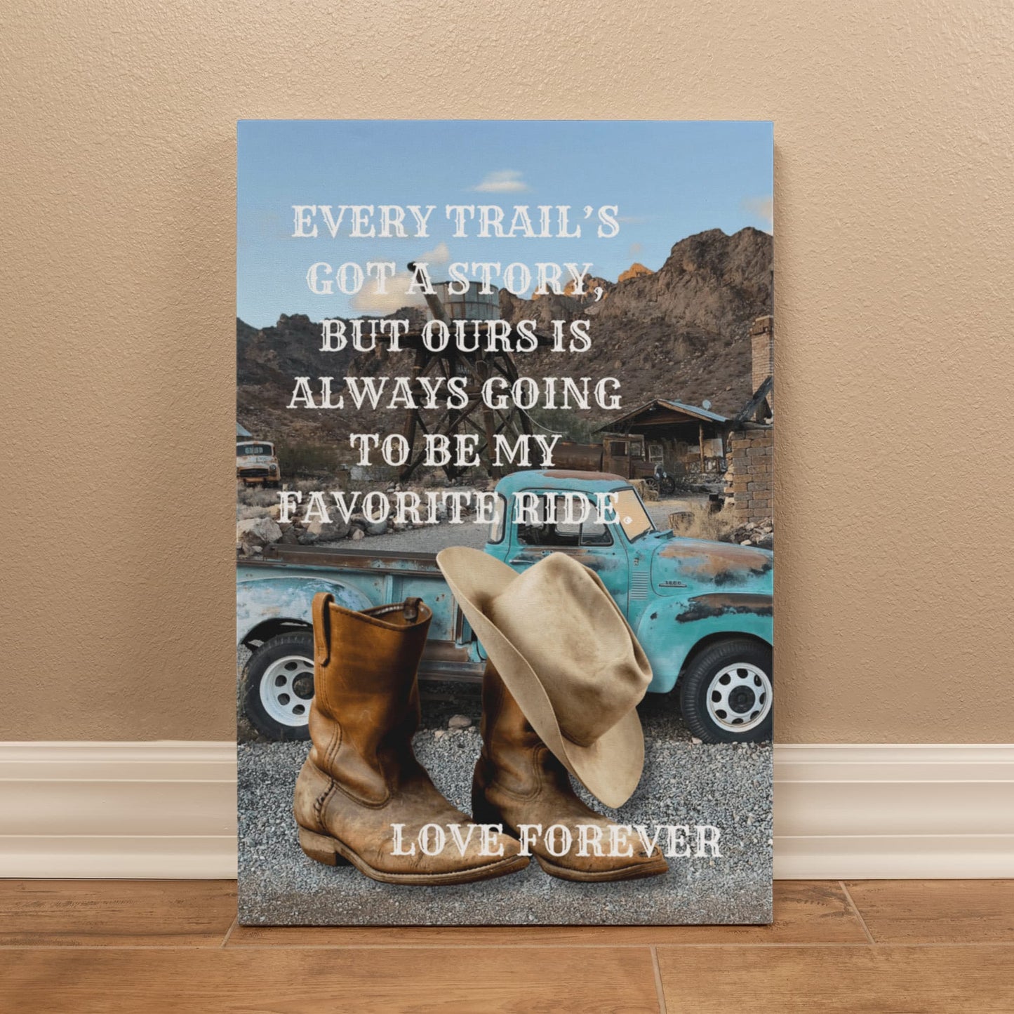 Canvas print with cowboy boots, hat, and vintage truck on a mountain background with text.