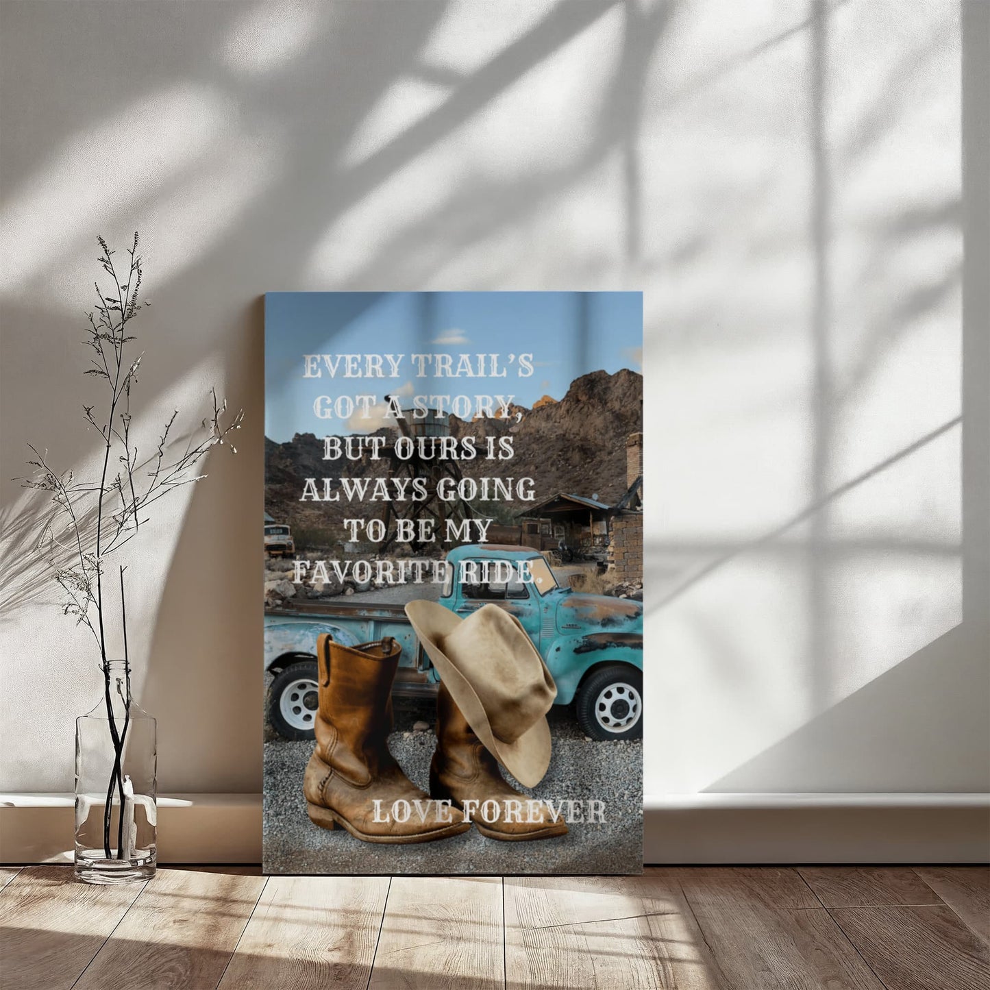 Decorative wall art with a blue truck, cowboy boots, and hats on a gray background with a motivational quote.