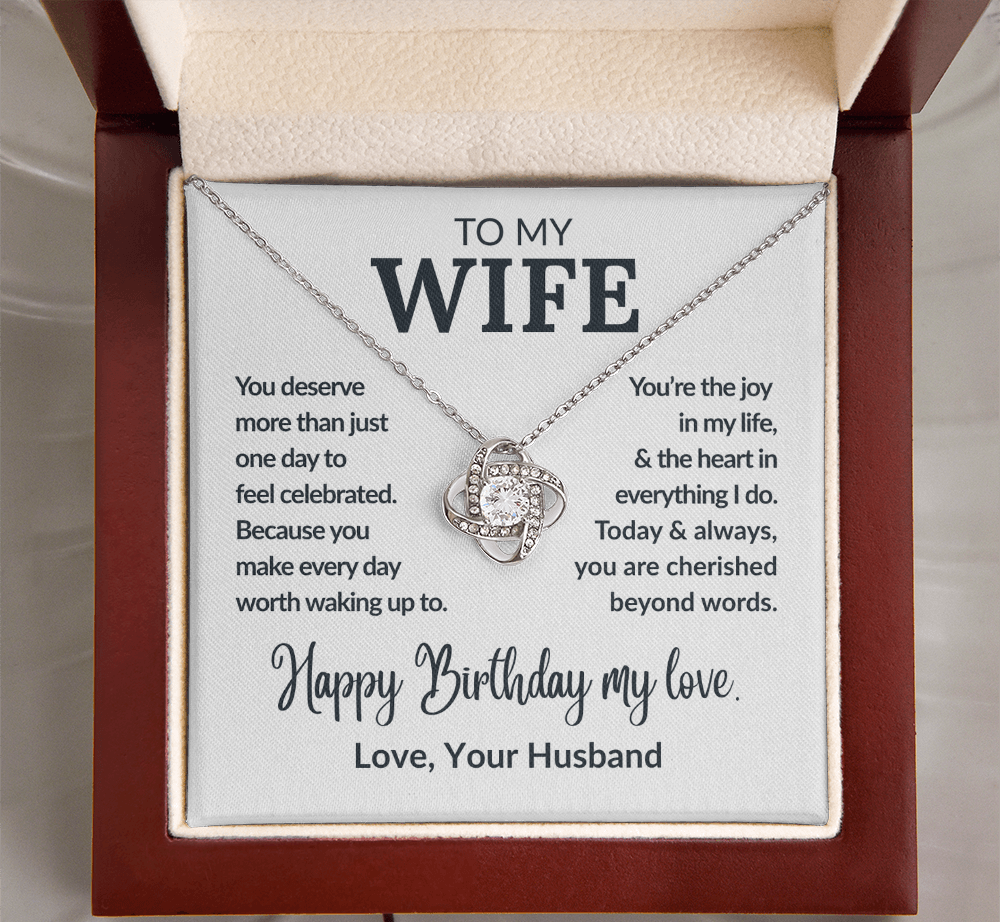 Necklace with a sentimental message card for a wife, placed in an open jewelry box.