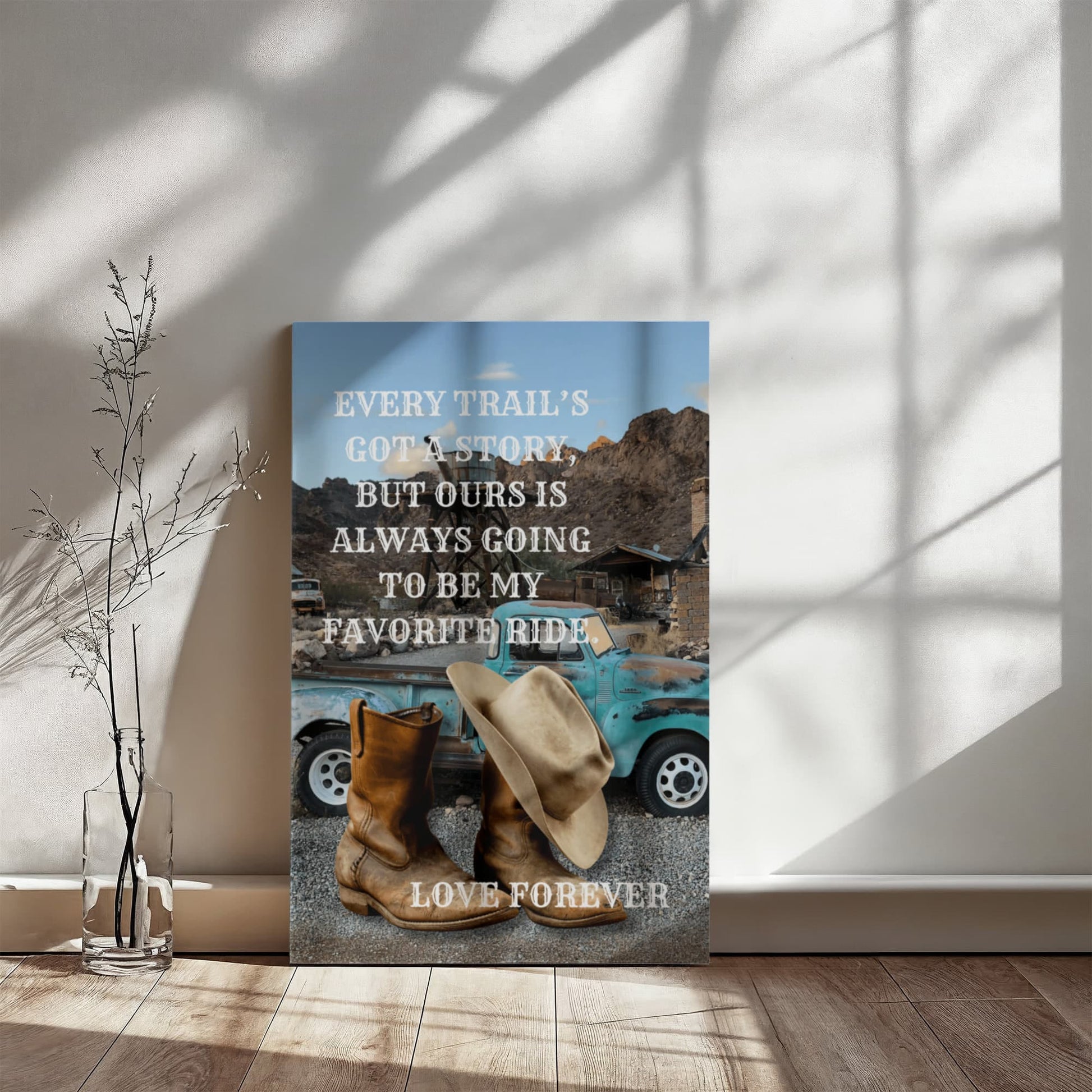 Decorative wall art with a blue truck, cowboy boots, and hats on a gray background with a motivational quote.